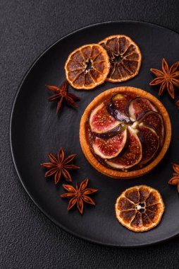 İncirli tatlı tart, peynirli krema ve fındıklı koyu beton arka plan