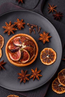 İncirli tatlı tart, peynirli krema ve fındıklı koyu beton arka plan