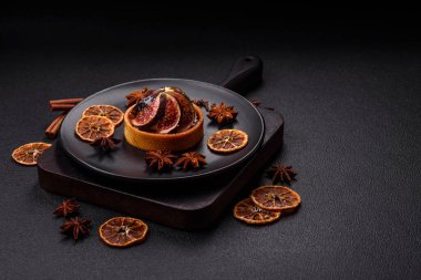 İncirli tatlı tart, peynirli krema ve fındıklı koyu beton arka plan