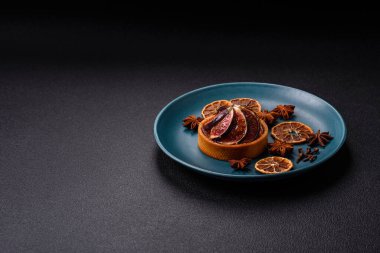 İncirli tatlı tart, peynirli krema ve fındıklı koyu beton arka plan