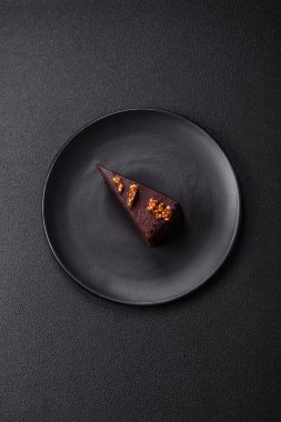 Koyu beton arka planda fındıklı bir parça çikolatalı pasta.