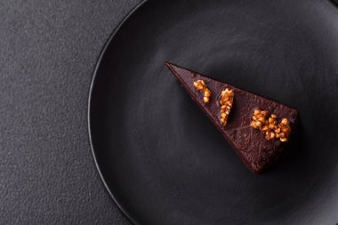 Koyu beton arka planda fındıklı bir parça çikolatalı pasta.