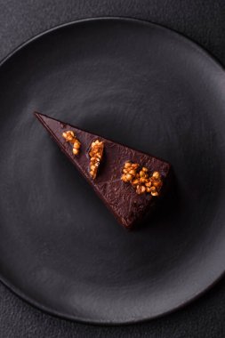 Koyu beton arka planda fındıklı bir parça çikolatalı pasta.