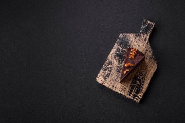 Koyu beton arka planda fındıklı bir parça çikolatalı pasta.