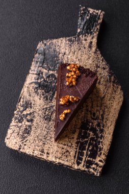 Koyu beton arka planda fındıklı bir parça çikolatalı pasta.