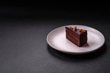 Koyu beton arka planda fındıklı bir parça çikolatalı pasta.