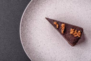 Koyu beton arka planda fındıklı bir parça çikolatalı pasta.