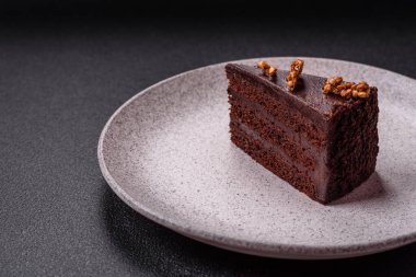 Koyu beton arka planda fındıklı bir parça çikolatalı pasta.