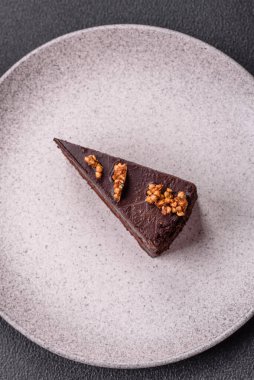 Koyu beton arka planda fındıklı bir parça çikolatalı pasta.