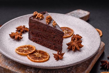 Koyu beton arka planda fındıklı bir parça çikolatalı pasta.