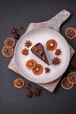 Koyu beton arka planda fındıklı bir parça çikolatalı pasta.