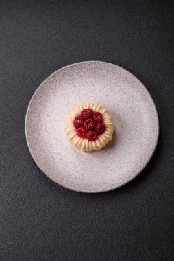 Ahududulu tatlı kremalı tart ve koyu beton bir arka plan