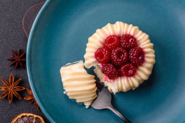 Ahududulu tatlı kremalı tart ve koyu beton bir arka plan