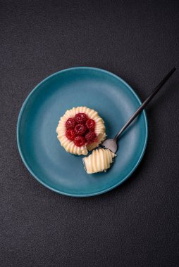 Ahududulu tatlı kremalı tart ve koyu beton bir arka plan