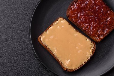 Tost ekmekli sandviç, fıstık ezmesi ve ahududu ya da çilek reçeli. İçten, besleyici bir kahvaltı.