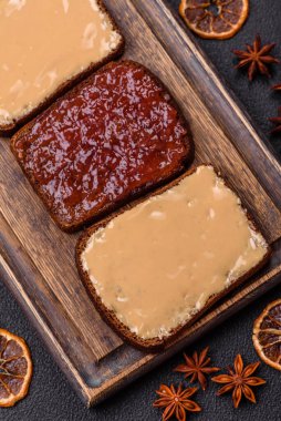 Tost ekmekli sandviç, fıstık ezmesi ve ahududu ya da çilek reçeli. İçten, besleyici bir kahvaltı.