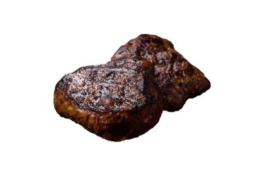 Izgarada pişirilmiş sulu biftek. Beyaz arka planda tuz, baharat ve otlarla.