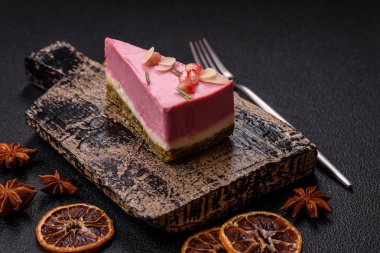 Pembe krem peynirli, ahududu aromalı veya koyu dokulu arkaplanda çilekli tatlı cheesecake.