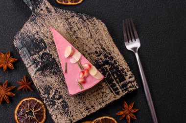 Pembe krem peynirli, ahududu aromalı veya koyu dokulu arkaplanda çilekli tatlı cheesecake.