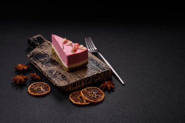 Pembe krem peynirli, ahududu aromalı veya koyu dokulu arkaplanda çilekli tatlı cheesecake.