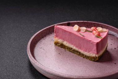 Pembe krem peynirli, ahududu aromalı veya koyu dokulu arkaplanda çilekli tatlı cheesecake.