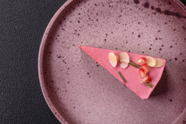 Pembe krem peynirli, ahududu aromalı veya koyu dokulu arkaplanda çilekli tatlı cheesecake.