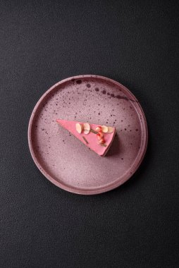 Pembe krem peynirli, ahududu aromalı veya koyu dokulu arkaplanda çilekli tatlı cheesecake.