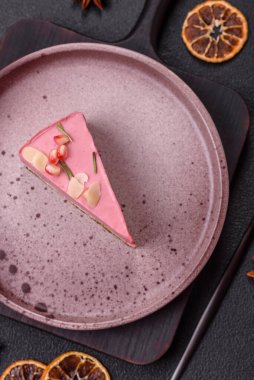 Pembe krem peynirli, ahududu aromalı veya koyu dokulu arkaplanda çilekli tatlı cheesecake.