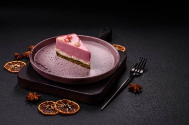 Pembe krem peynirli, ahududu aromalı veya koyu dokulu arkaplanda çilekli tatlı cheesecake.