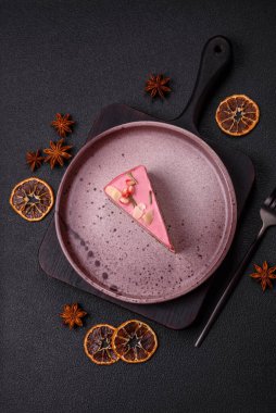 Pembe krem peynirli, ahududu aromalı veya koyu dokulu arkaplanda çilekli tatlı cheesecake.