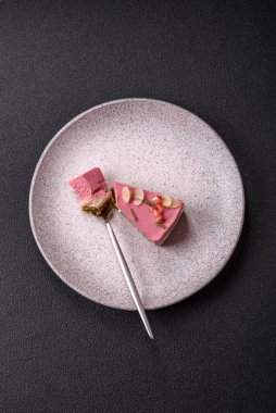 Pembe krem peynirli, ahududu aromalı veya koyu dokulu arkaplanda çilekli tatlı cheesecake.