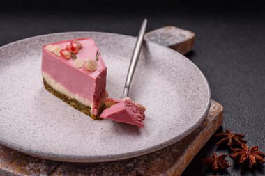 Pembe krem peynirli, ahududu aromalı veya koyu dokulu arkaplanda çilekli tatlı cheesecake.