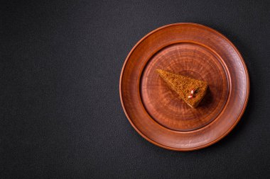 Koyu desenli beton arka planda tatlı katmanlı ballı kek.