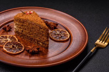 Koyu desenli beton arka planda tatlı katmanlı ballı kek.