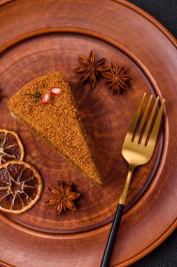 Koyu desenli beton arka planda tatlı katmanlı ballı kek.