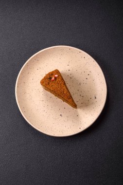 Koyu desenli beton arka planda tatlı katmanlı ballı kek.