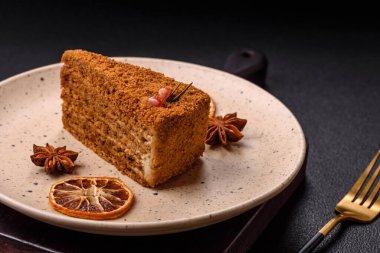 Koyu desenli beton arka planda tatlı katmanlı ballı kek.