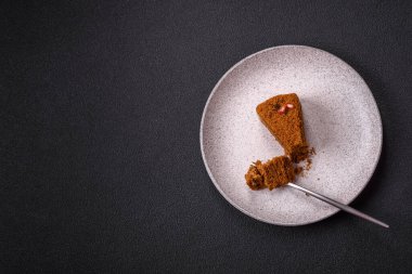 Koyu desenli beton arka planda tatlı katmanlı ballı kek.