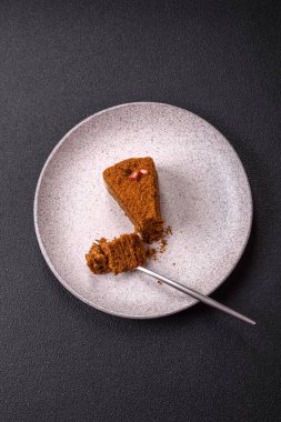 Koyu desenli beton arka planda tatlı katmanlı ballı kek.