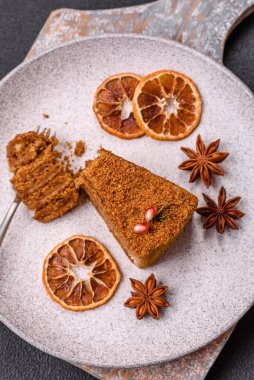 Koyu desenli beton arka planda tatlı katmanlı ballı kek.