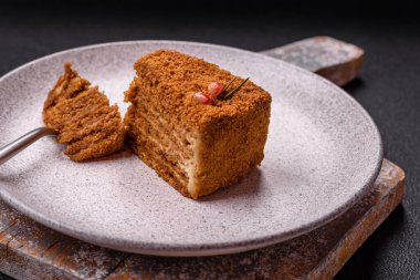 Koyu desenli beton arka planda tatlı katmanlı ballı kek.