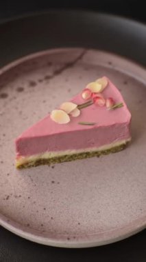 Pembe krem peynirli, ahududu aromalı veya koyu dokulu arkaplanda çilekli tatlı cheesecake.