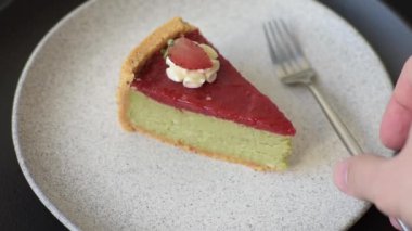 Koyu dokulu arka planda fıstık ve krem peynirli fırında çilekli kek yok.