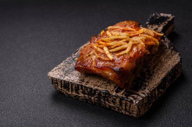 Koyu beton bir arka planda ızgarada pişirilmiş tuzlu, baharatlı ve otlu domuz ya da biftek kaburgası.