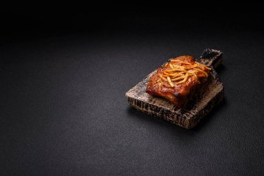 Koyu beton bir arka planda ızgarada pişirilmiş tuzlu, baharatlı ve otlu domuz ya da biftek kaburgası.