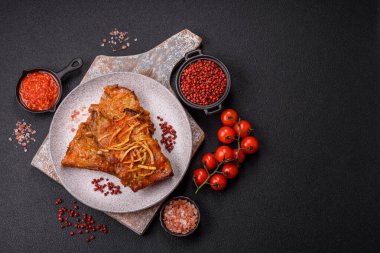 Koyu beton bir arka planda ızgarada pişirilmiş tuzlu, baharatlı ve otlu domuz ya da biftek kaburgası.