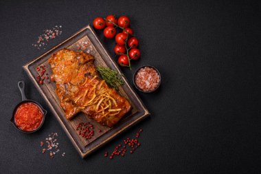 Koyu beton bir arka planda ızgarada pişirilmiş tuzlu, baharatlı ve otlu domuz ya da biftek kaburgası.