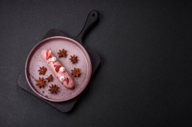 Koyu dokulu arka planda çilekli kremalı tatlı ekler veya profiterol.