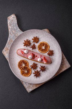 Koyu dokulu arka planda çilekli kremalı tatlı ekler veya profiterol.