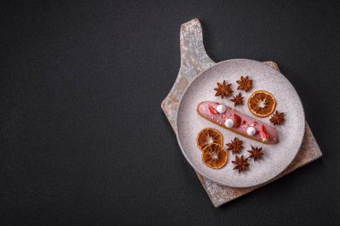 Koyu dokulu arka planda çilekli kremalı tatlı ekler veya profiterol.